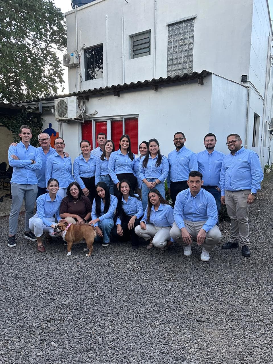 Equipe administrativa da Mercoservice reunida em frente à sede da empresa